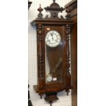 An early 20th century stained walnut small Vienna droptrunk wall clock, with pendulum, approx h.
