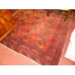 A Persian woollen red ground Bokhara rug, the central repeating ground within trailing tramline