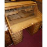 An early 20th century light oak kneehole rolltop desk, w.106cm