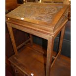 An early 20th century relief carved oak slopefront hinge topped compartment desk, on integral stand,
