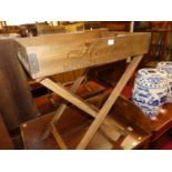 A contemporary stained pine and metal bound twin handled butler's tray on X-framed folding stand,