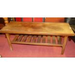 A 1970s teak long rectangular coffee table, having a laddered undertier (staining, water and heat