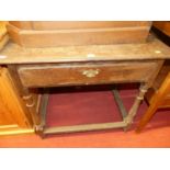 An antique joined and planked topped oak single drawer side table, raised on turned supports to