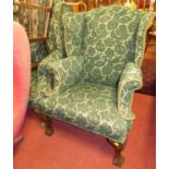 Two similar early 20th century and later green fabric upholstered wingback scroll armchairs, each