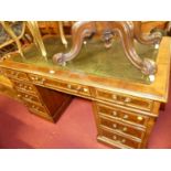 A contemporary walnut, burr walnut, and feather banded twin pedestal writing desk, having gilt