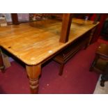 A long stained pine round cornered farmhouse kitchen table, raised on turned supports, length 225cm