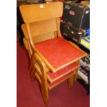 A set of three 1950s beech bar back stacking school chairs, each having floral vinyl red fixed pad