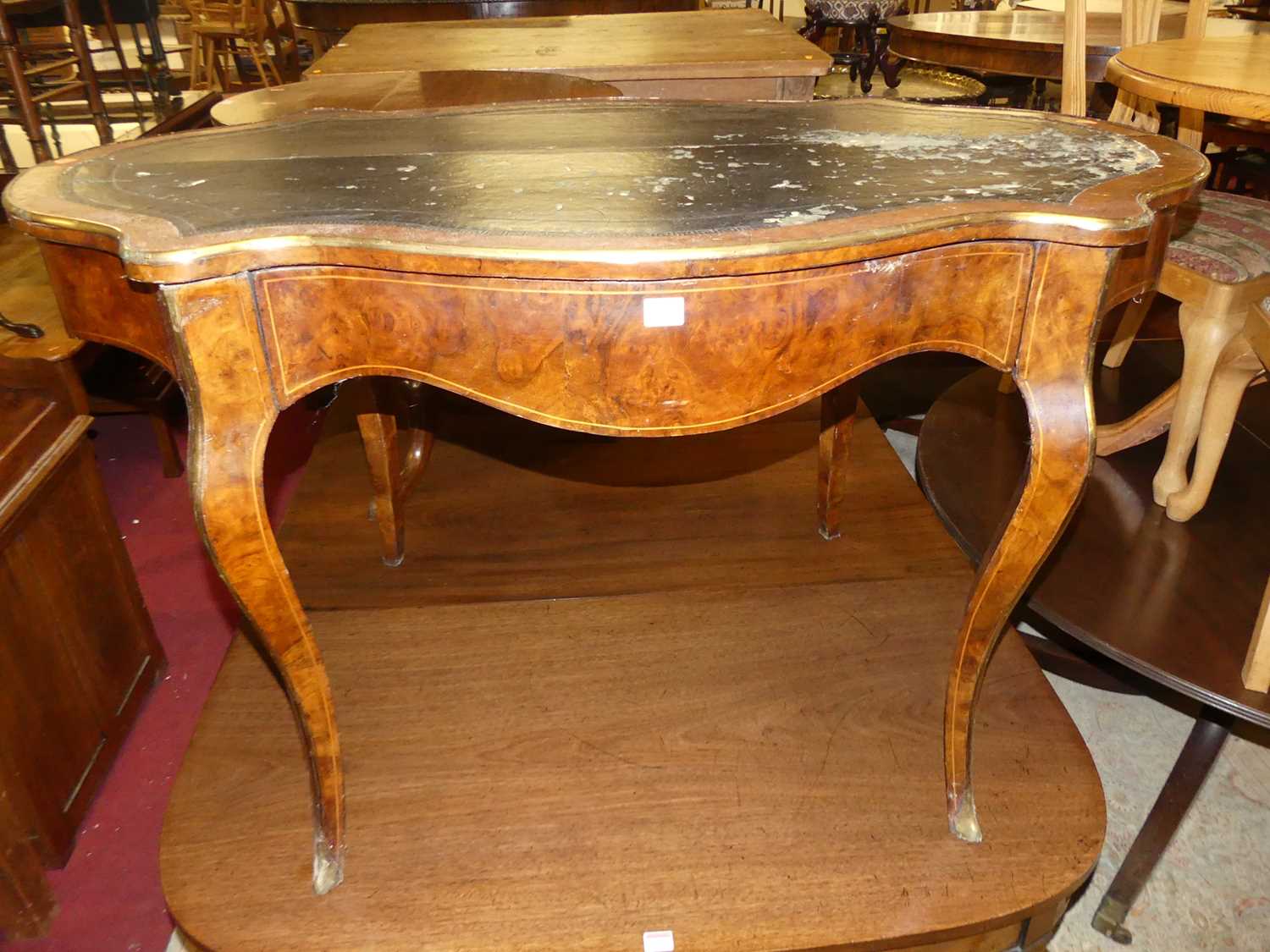 A circa 1900 French figured walnut and brass mounted shaped top single drawer writing table,