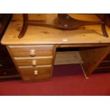 A modern pine round cornered single pedestal kneehole desk, having an arrangement of three