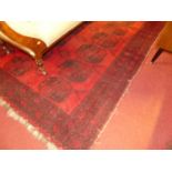 A Persian woollen red ground Bokhara rug, 220 x 157cm