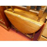 A 1930s barley twist oak drop leaf table having a gateleg action