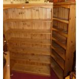 A large contemporary pine corner bookshelf, comprised of two sections