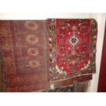 An extremely worn and faded Persian red ground woollen Bokhara rug; together with a small Persian