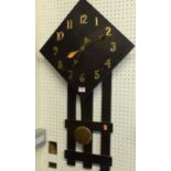 An Arts & Crafts influenced oak wall clock, having a lozenge dial, applied brass hands and