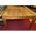 A 19th century planked pine farmhouse kitchen table, having single end drawer and raised on square