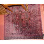 A Persian woollen red ground Bokhara rug, the repeating central ground within numerous trailing