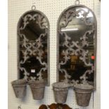 A pair of aged galvanised metal framed arched garden wall mirrors, with floral design and twin