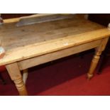 A rustic pine plank top round cornered farmhouse kitchen table, having single end drawer on raised