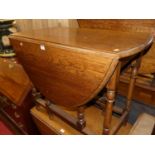 A 1930s oak drop leaf table having a gateleg action