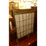 A late Victorian gilt brass and bevelled glass inset fire screen with floral silk inset backing,