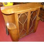 An Art Deco figured walnut round cornered double door glazed cabinet display, the open side upper