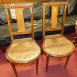 A pair of early 20th century French walnut cane seat bedroom chairs