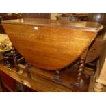 An early 20th century barley twist oak drop leaf dining table, having gateleg action