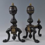 A pair of Victorian cast iron and brass fire dogs / andirons, each with raised roundels, on lion paw