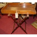 A 19th century mahogany twin handled butler's tray, raised on mahogany simulated bamboo folding X