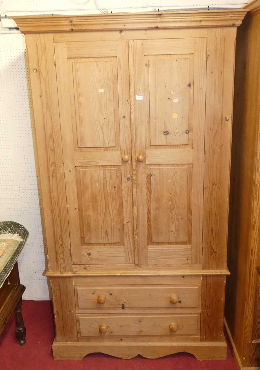 A modern pine double door wardrobe, having twin long lower drawers, w.110cm