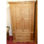 A modern pine double door wardrobe, having twin long lower drawers, w.110cm