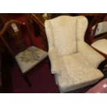 An early 20th century stained beech framed and cream floral upholstered wing back armchair, width