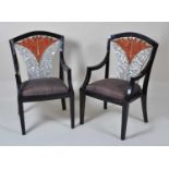 A pair of probably American Art Deco black lacquered and mother of pearl inset elbow chairs, the