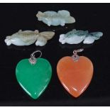 A green hardstone carved heart pendant; together with a similar orange hardstone example; and