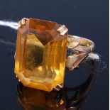 A modern yellow metal and orange citrine tablet ring, having a four claw set baguette cut orange