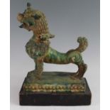 A Chinese green glazed pottery figure of a Fu Lion, modelled in proud standing pose, mounted on a