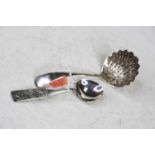An early 20th century silver sifting spoon having a pierced shell shaped bowl and plain terminal