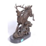 A bronze model of a running stag, upon a naturalistic base, mounted upon a slate plinth, h.