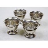 A set of four George V silver open salts, each having a flared rim to a tapering bowl and domed