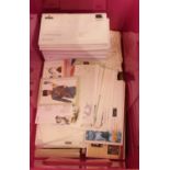 A box containing a collection of various first day covers and postcards