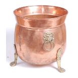 An early 20th century copper and brass jardiniere, flanked by brass lion mask ring handles, standing