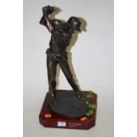 A bronzed resin figure of a golfer, mounted on a wooden plinth, 49cm high