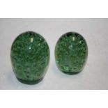 A Victorian green glass end-of-day weight with bubble inclusions, height 12cm, together with one