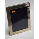 A modern silver clad easel photo frame of plain rectangular form, 25x20cm