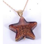 A gilded amber glass star shaped pendant with 9ct gold bale and on 9ct gold finelink neck chain