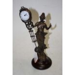 A modern Spelter mystery clock in the form of a maiden in standing pose, on socle base, the clock