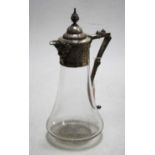 A Victorian style claret jug having a clear glass body with silver plated mount and Bacchus mask