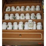 A collection of Franklin Mint Gloria Concepts herb and spice jars, within a spice rack