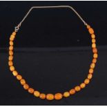 A faux beaded and graduated butterscotch amber necklace, with additional 9ct gold flatlink chain,