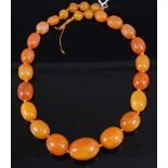 A faux butterscotch amber barrel bead necklace, comprising 24 mixed beads on a knotted string, gross